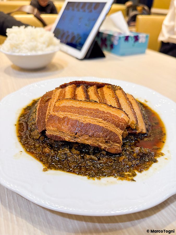 Un piatto di maiale a Mara Daigaku servito con verdure su un tavolo in un ristorante cinese a Ueno.