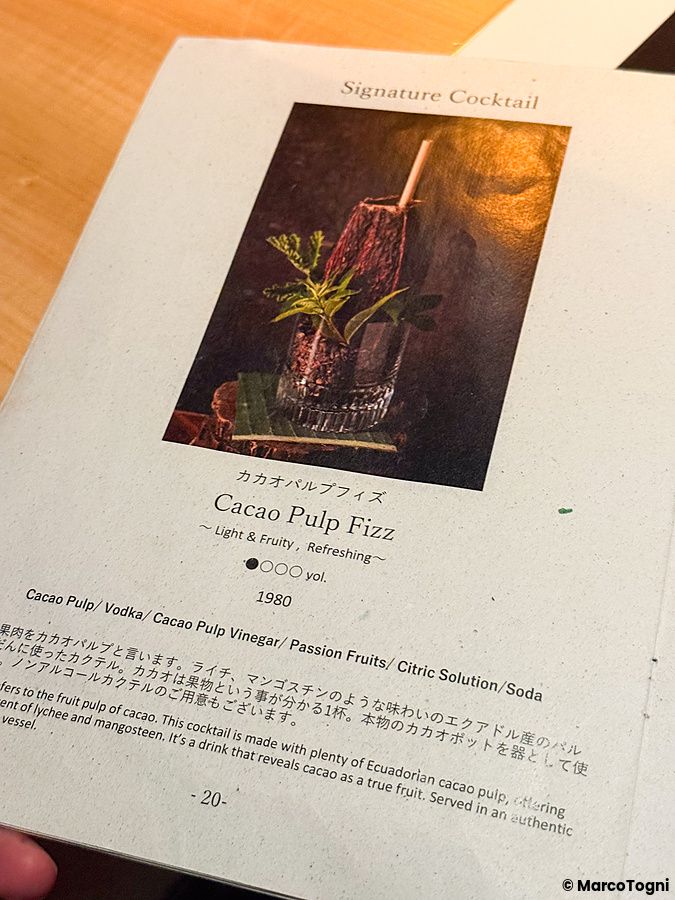 Pagina di un menu del bar Memento Mori a Tokyo che presenta il cocktail Cacao Pulp Fizz servito in un baccello di cacao.