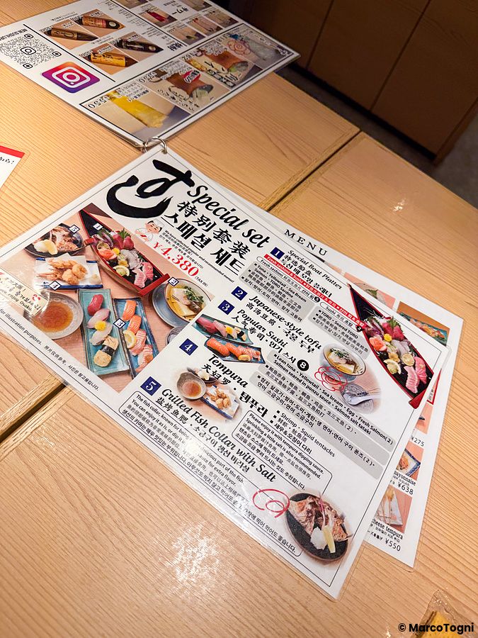 Menù illustrato del ristorante New Sushi Center Harukiya, sede di Ura-Namba Branch ad Osaka, con foto di set di sushi.