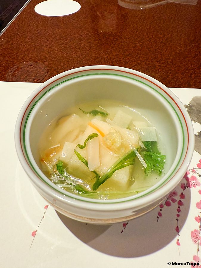 Mochi al latte di soia con salsa densa alle verdure servito in una ciotola decorata al ristorante Ume no Hana di Ginza.