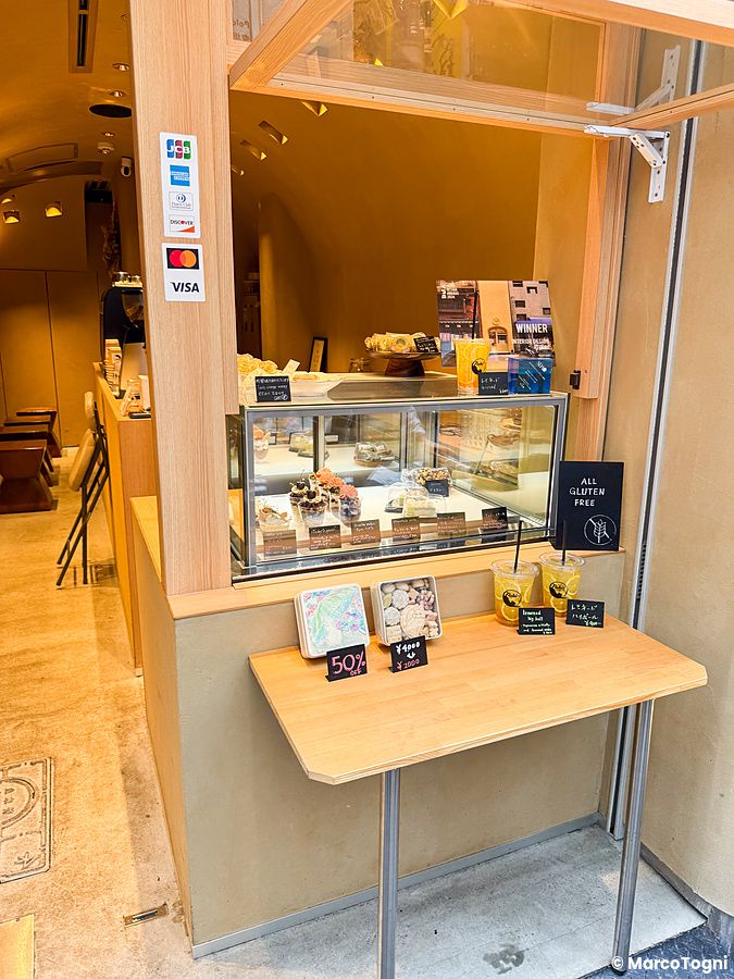 Vetrina di Naki vegan sweets a Osaka con dolci esposti e un banco esterno in legno.