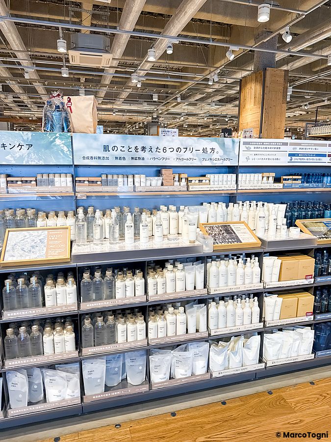 Scaffali del negozio Muji, a Tokyo, con un'ampia esposizione di flaconi e prodotti per la cura della pelle.