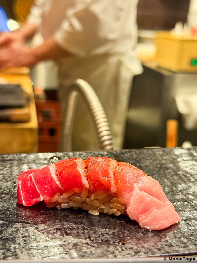 Un pezzo di otoro servito su un piatto di pietra presso Kaiten Sushi Ginza Onodera nel quartiere Omotesando.