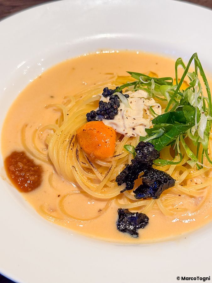 Pasta vegana con riccio di mare, caviale, yuba e crema di soia servita in un piatto bianco al Green Italian Torcia.
