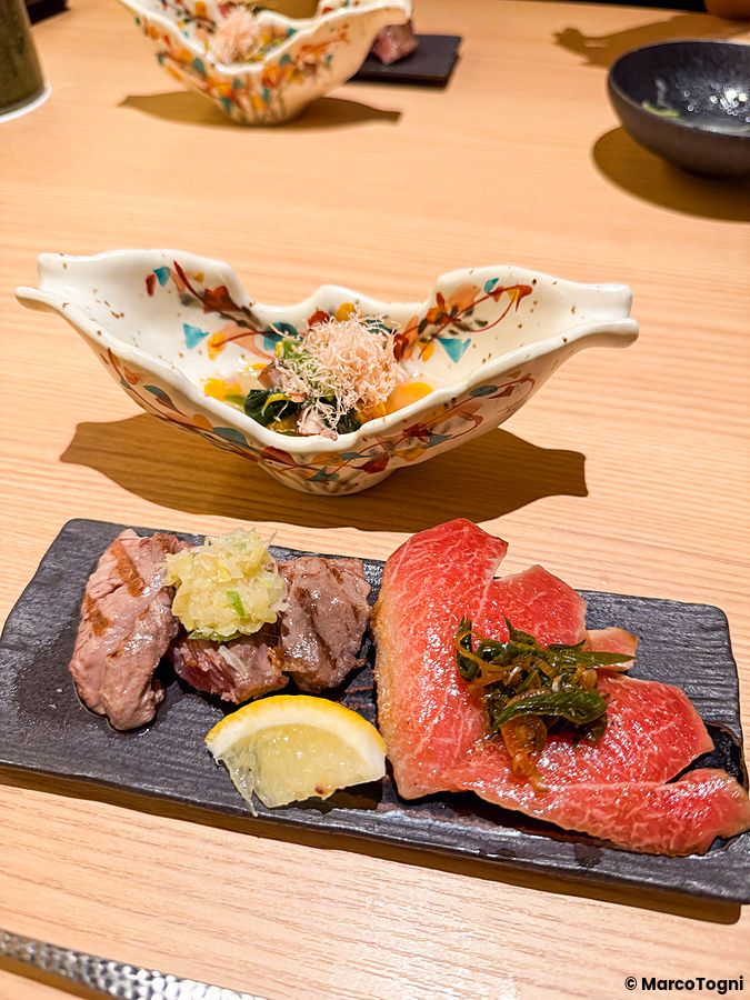 Pesce grigliato a Yakiuo Ishikawa servito su un vassoio di ardesia con limone in un ristorante a Roppongi, Tokyo.