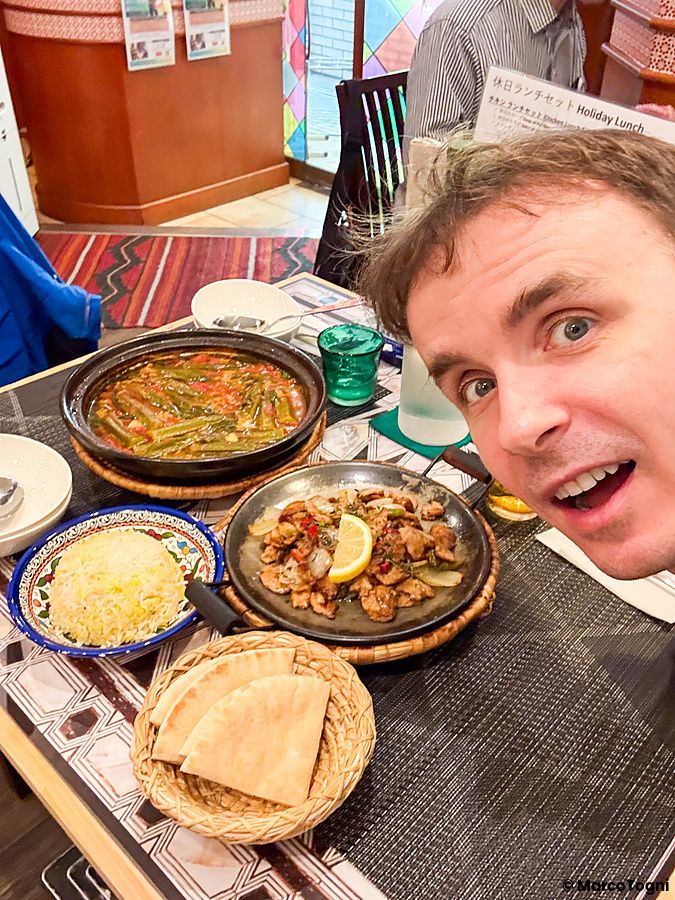 Marco Togni scatta un selfie in un ristorante arabo ad Osaka con piatti vegani a Seven Hills disposti sul tavolo.