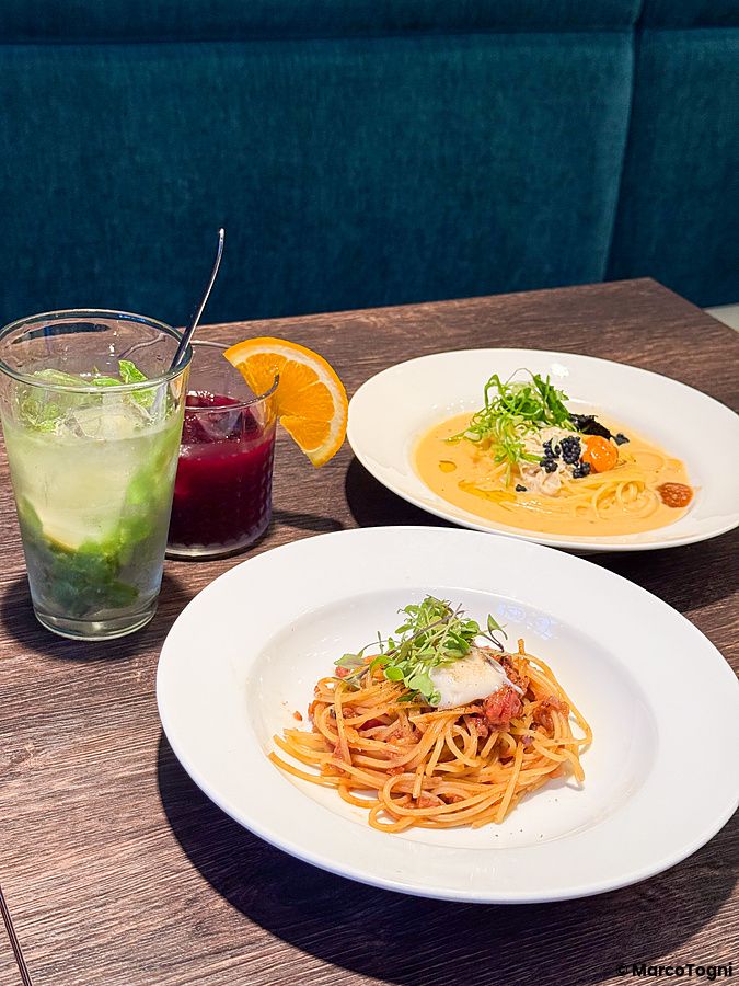 Due piatti di pasta vegana e bevande sul tavolo di Green Italian Torcia a Shinjuku, Tokyo.
