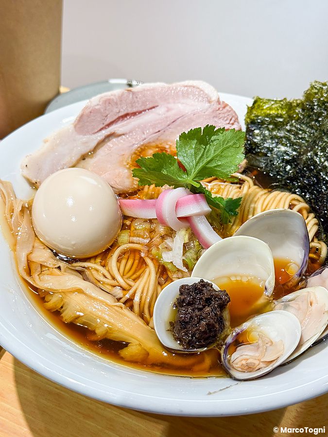 Una ciotola di ramen alle vongole con uovo, carne e pasta di olive servita nel ristorante Mugi to Olive a Tokyo.