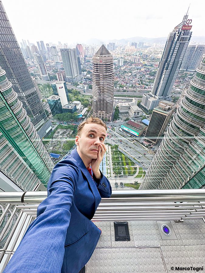 Marco Togni in giacca blu scatta un selfie sul punto panoramico delle Torri Petronas.