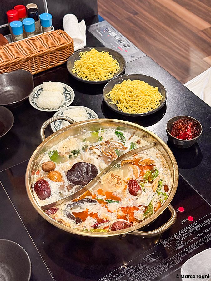pentola di shabu shabu vegano con verdure e funghi e contorni al ristorante Kinnome a Tokyo