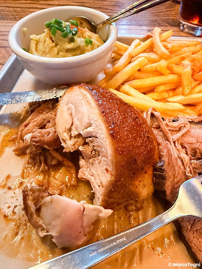 Carne arrosto, patatine fritte e purè di patate serviti su un vassoio di metallo presso il ristorante Smokehouse.
