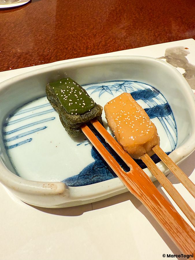 Due spiedini di glutine di nama-fu grigliati con glassa di miso serviti su un piatto decorato al ristorante Ume no Hana.