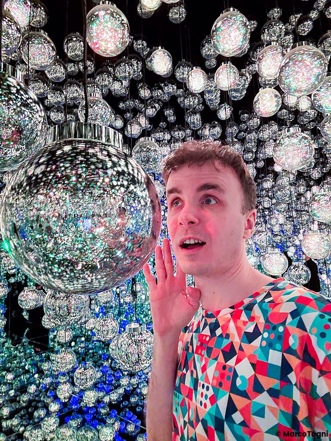 Marco Togni osserva con stupore le sfere luminose sospese nella stanza delle lanterne a teamLab Borderless Tokyo.