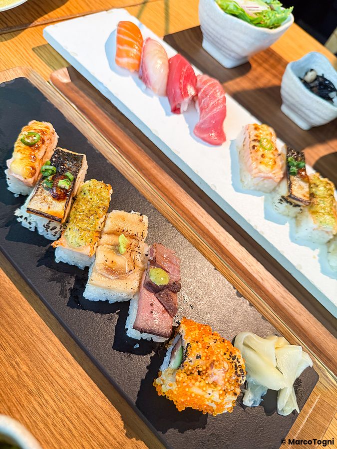 Sushi aburicious e tradizionale servito su piatti in ardesia e ceramica al Kinka Sushi Bar Izakaya di Shibuya.