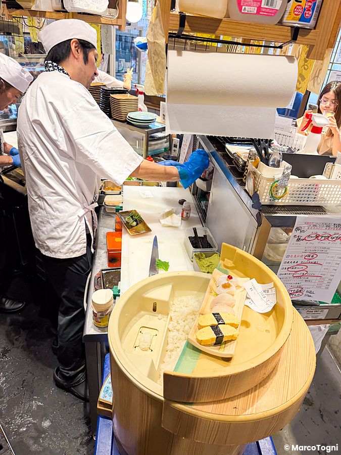 Uno chef prepara il sushi dietro al bancone nel Ristorante New Sushi Center Harukiya, sede di Ura-Namba Branch a Osaka.