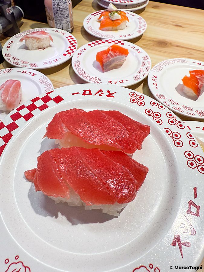 Piatti di sushi serviti presso il ristorante Sushiro disposti su un tavolo di legno.