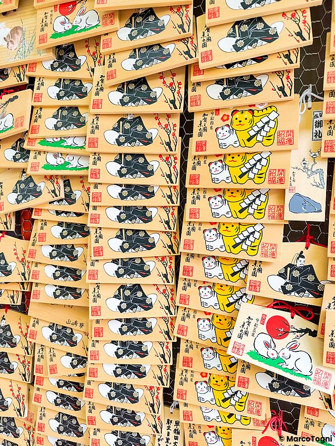 Molteplici tavolette ema di legno con illustrazioni di conigli e tigri appese in un santuario a Shinjuku, Tokyo.