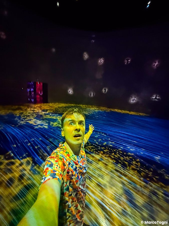 Marco Togni scatta un selfie immerso nelle proiezioni luminose artistiche del teamLab Borderless Tokyo.