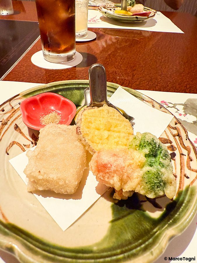 Un piatto di tempura di verdure servito su ceramica decorata presso il ristorante Ume no Hana a Ginza.