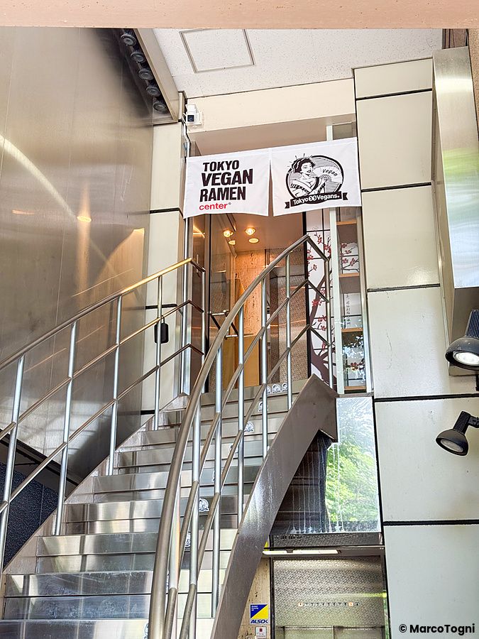 L'ingresso rialzato con scala in metallo del ristorante Tokyo Vegan Ramen Center ad Harajuku, Tokyo.