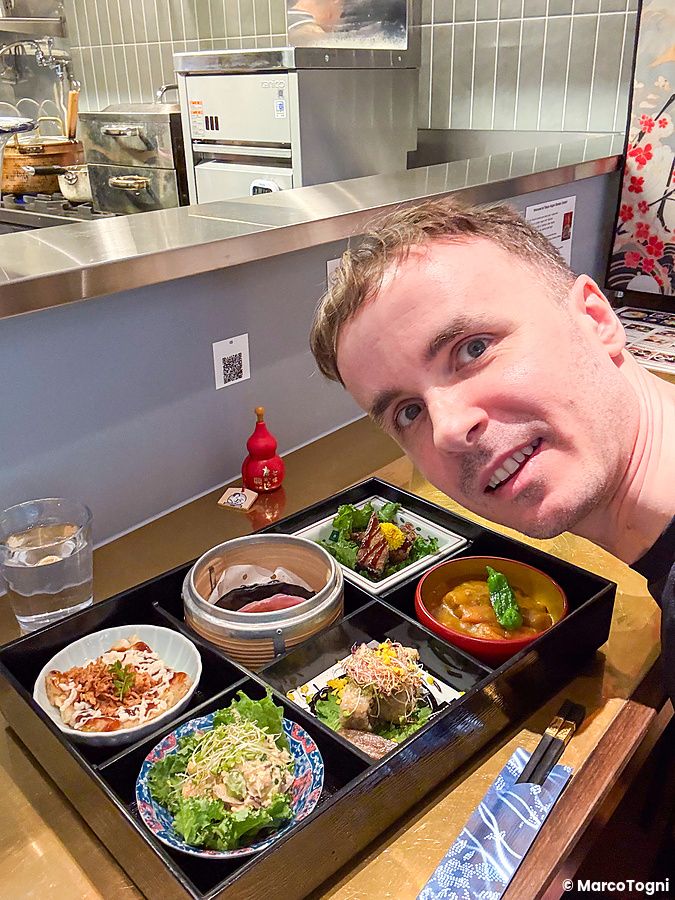 Marco Togni si scatta un selfie davanti a un piatto misto a Tokyo Vegan Ramen Center situato a Harajuku.