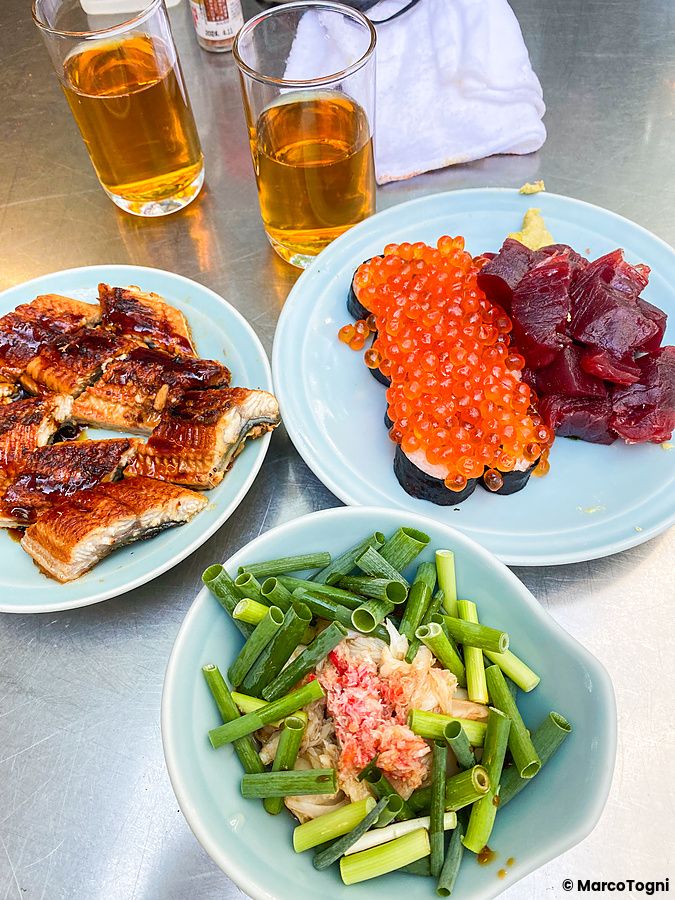 Piatti di anguilla, maki con ikura, tonno e verdure su un tavolo metallico presso il locale Toyo Izakaya a Osaka.