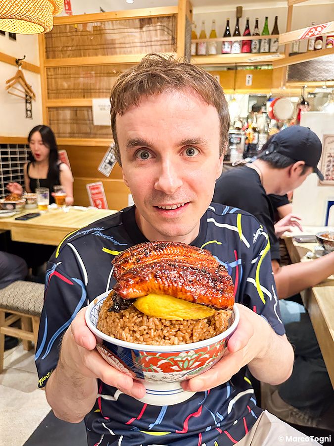 Marco Togni regge una ciotola con riso e anguilla grigliata presso il ristorante Izumo a Osaka.