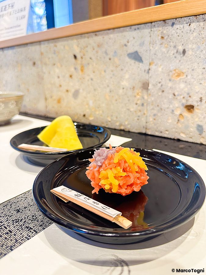Wagashi preparato a mano su un piatto nero nel negozio Tsuruya Yoshinobu a Nihonbashi.