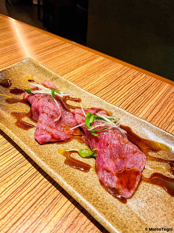 Due pezzi di nigiri di wagyu A5 serviti su un piatto rettangolare presso il ristorante Cossott'e SP a Tokyo.