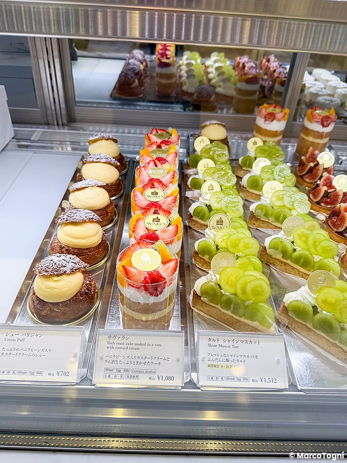 Vetrina con dolci a Wako Tea Salon a Ginza, con file di bignè, bicchierini di frutta e crostate di uva Shine Muscat.