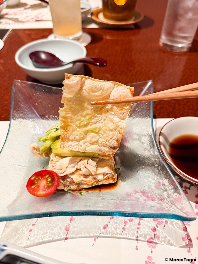Yuba sollevato con bacchette su un piatto di vetro al ristorante Ume no Hana di Ginza.
