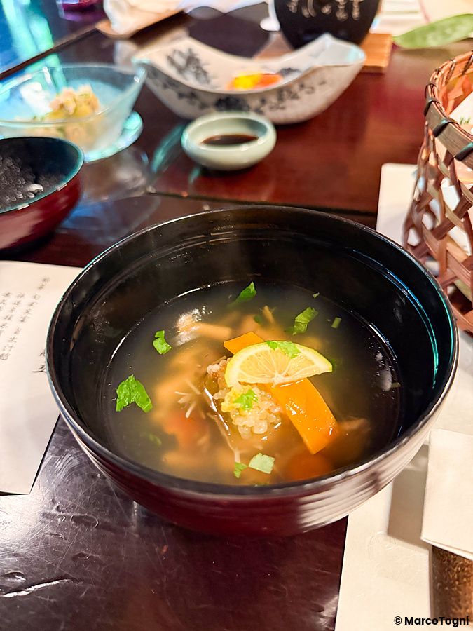 Zuppa fumante in una ciotola scura servita al ristorante Kurochaya ad Akiruno, Tokyo.