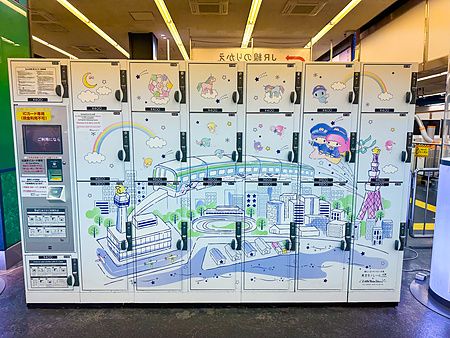 Un gruppo di coin locker di Little Twin Star decorati con illustrazioni di Tokyo in una stazione ferroviaria in Giappone.