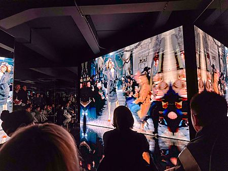 Pubblico che osserva le proiezioni della 2024 Artisanal Collection alla mostra di Maison Margiela a Tokyo.