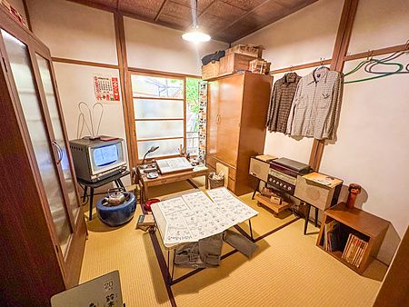 Una stanza del museo a Museo Manga Tokiwaso con pavimenti in tatami, mobili in legno, un vecchio televisore e tavole manga.