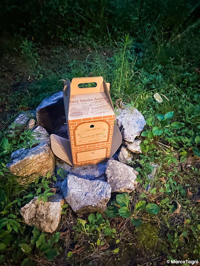 Scatola per affumicare cibo su pietre in un campeggio nella natura.
