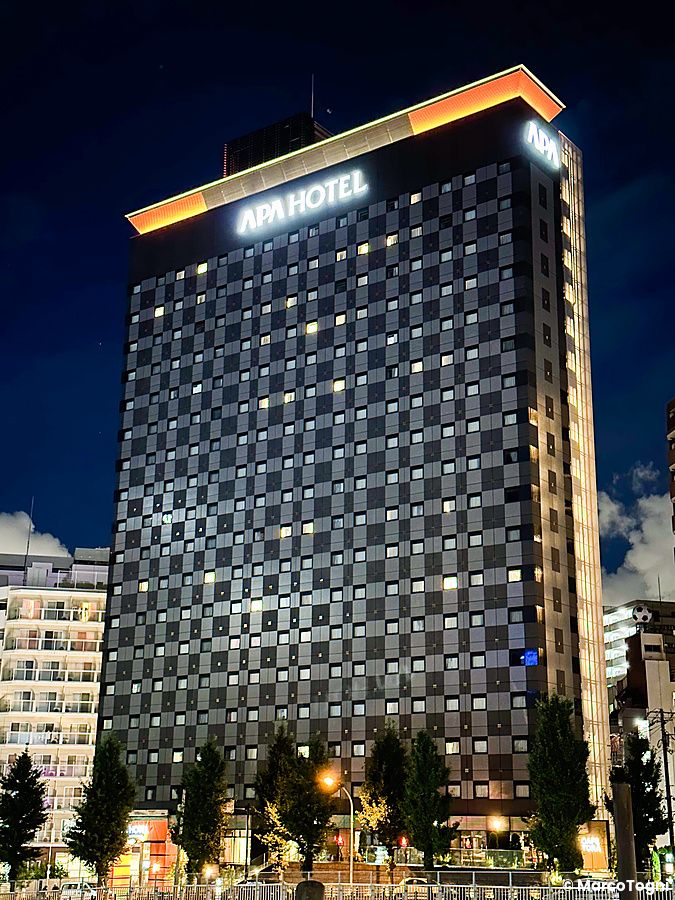 L'edificio illuminato del Apa Hotel Otsuka si erge contro il cielo notturno di Tokyo.