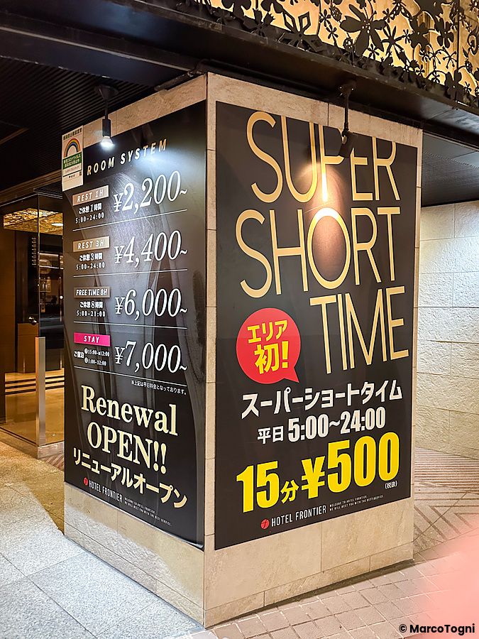 Cartellone pubblicitario nero con tariffe per un love hotel ad Otsuka a Tokyo, che mostra prezzi a partire da 500 yen.