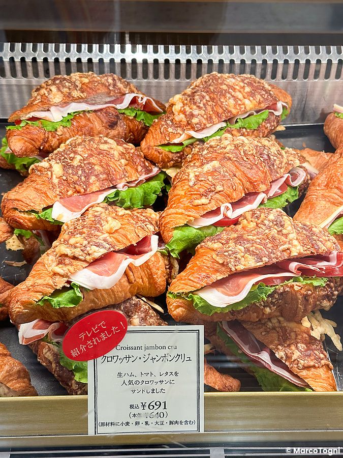 Croissant salati farciti con prosciutto crudo e lattuga in esposizione nella vetrina della catena Paul a Tokyo.