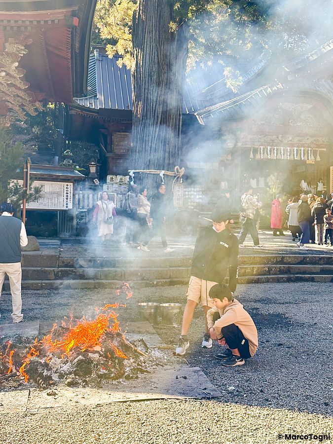 Fuoco cerimoniale durante l'hatsumode al Santuario Kitaguchihongu Fuji Sengenjinja a Fujiyoshida con persone presenti.
