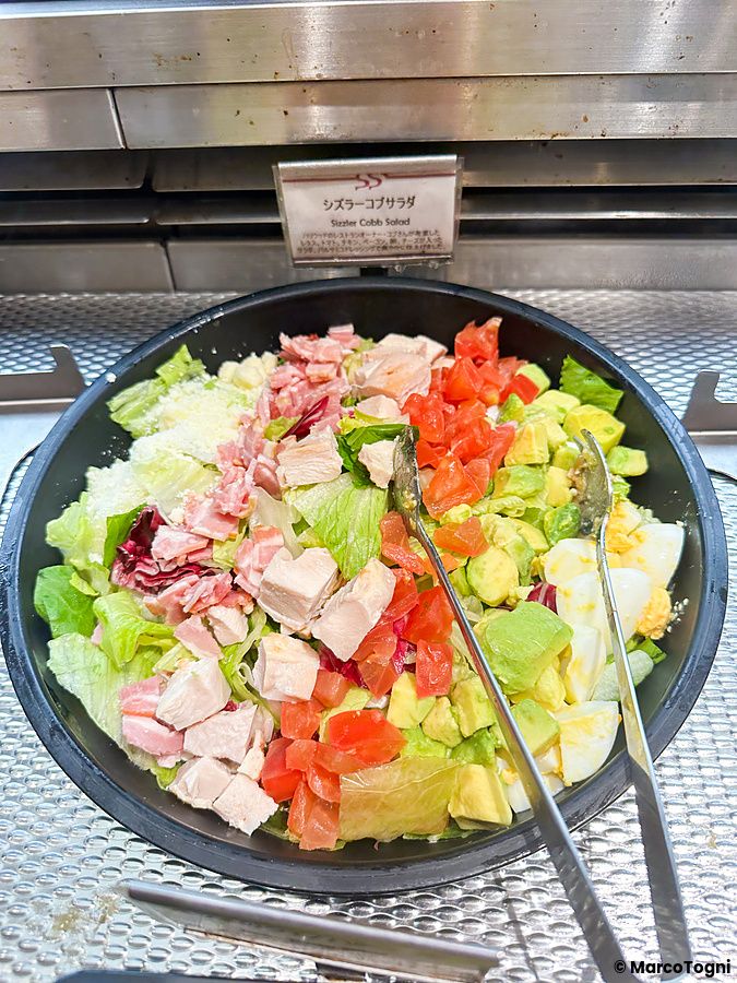 Una grande ciotola con un'insalata Cobb fresca esposta al buffet del ristorante Sizzler a Tokyo.