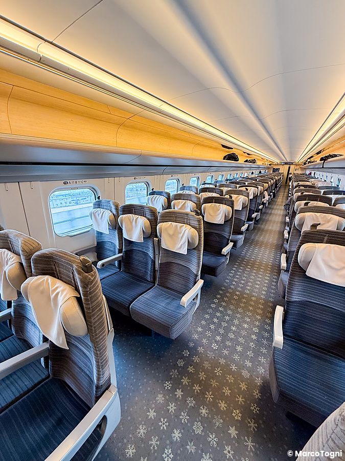 interno di un treno Shinkansen con sedili vuoti e illuminazione soffusa