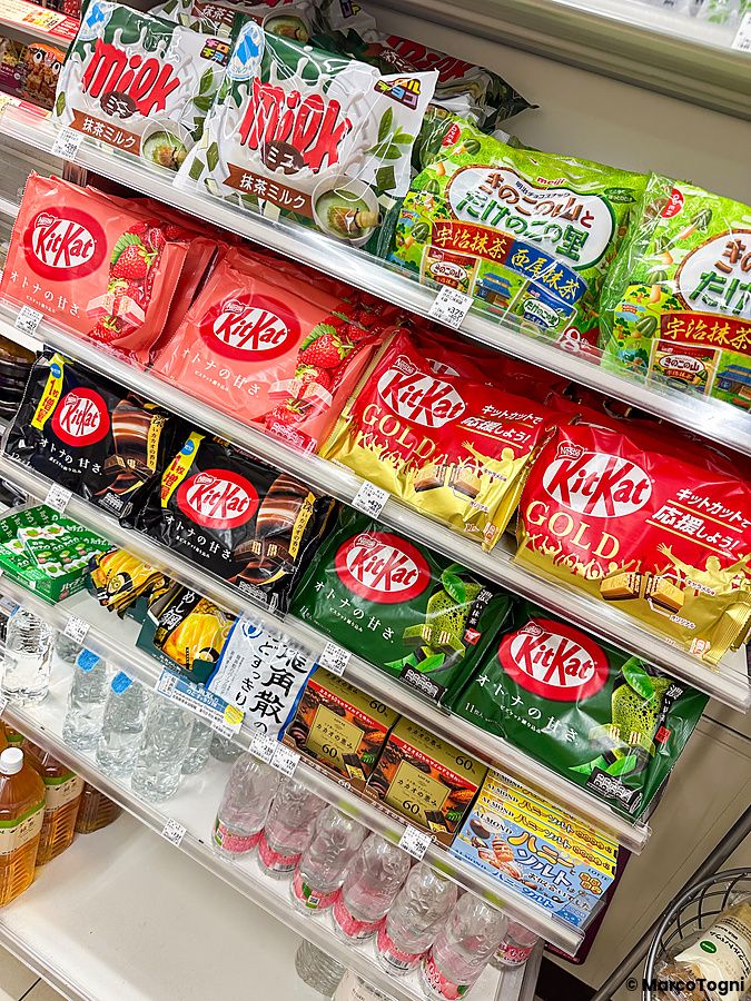 Scaffali di un negozio giapponese colmi di varie confezioni di KitKat in Giappone in diversi gusti e formati.