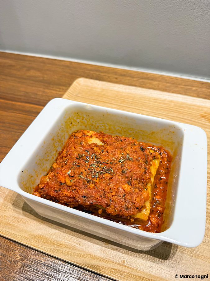 Lasagna vegana servita in una pirofila di ceramica bianca all'interno del locale HealthyTokyo.