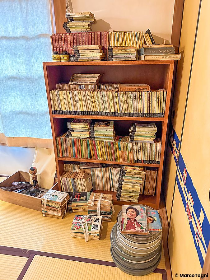 Una libreria in legno carica di vecchi libri e riviste all'interno di una stanza del museo a Museo Manga Tokiwaso.