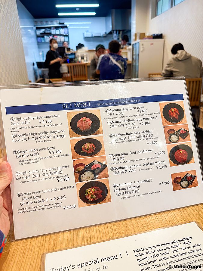 Un menu plastificato del ristorante Maguro Koya a Nara mostra varie opzioni di set di tonno con prezzi e foto.