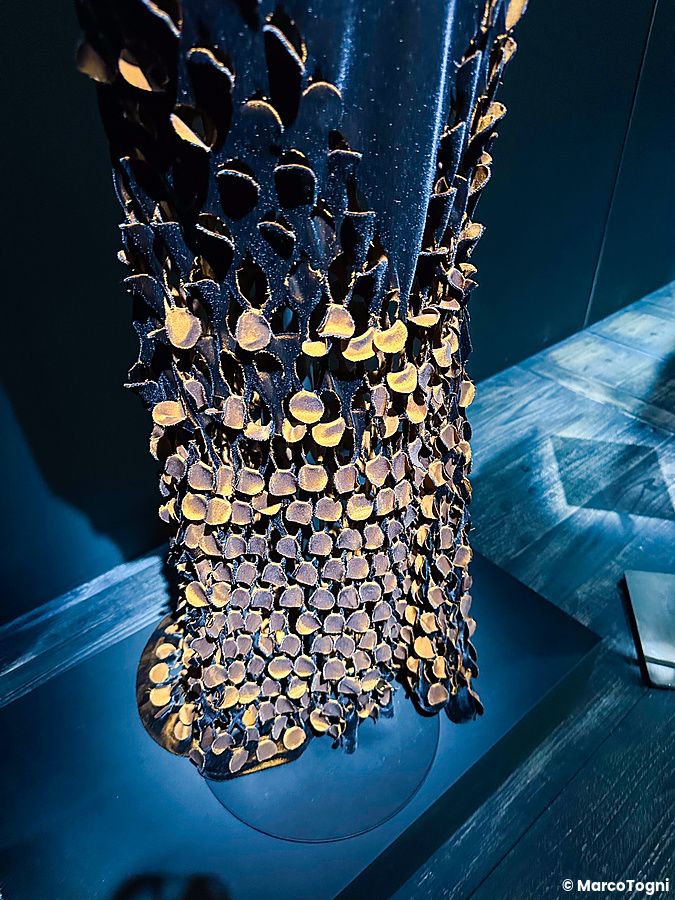 Dettaglio di un abito scultoreo con scaglie sovrapposte alla mostra di Maison Margiela a Tokyo.