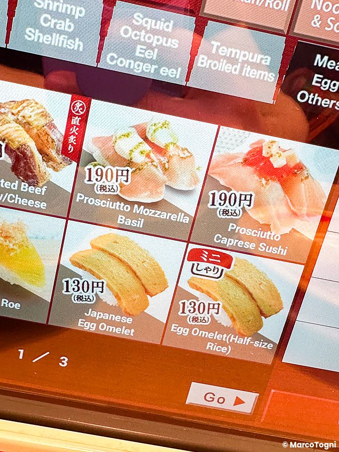 Schermo touch di un tablet del ristorante Sushiro in Giappone che mostra il menù con vari tipi di sushi e prezzi.