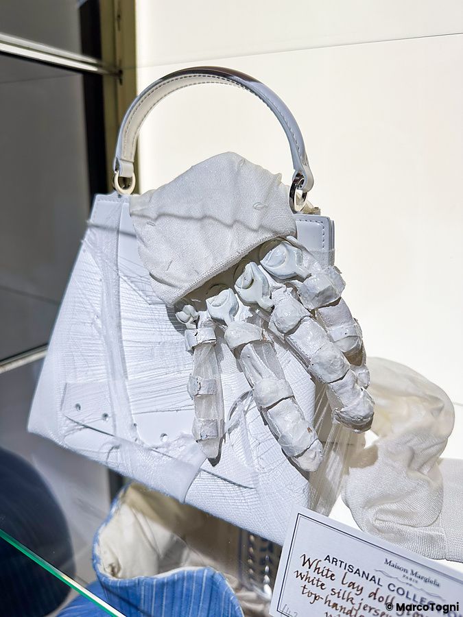 Una borsa bianca decorata con una mano scultorea in mostra alla 2024 Artisanal Collection di Maison Margiela a Tokyo.