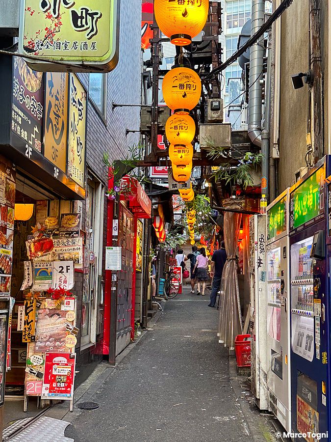 Vicolo con lanterne gialle e negozi a Omoide Yokocho, Tokyo
